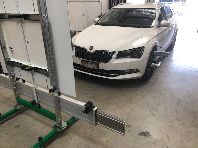 A vehicle set up for ADAS calibration with the target rig in the workshop