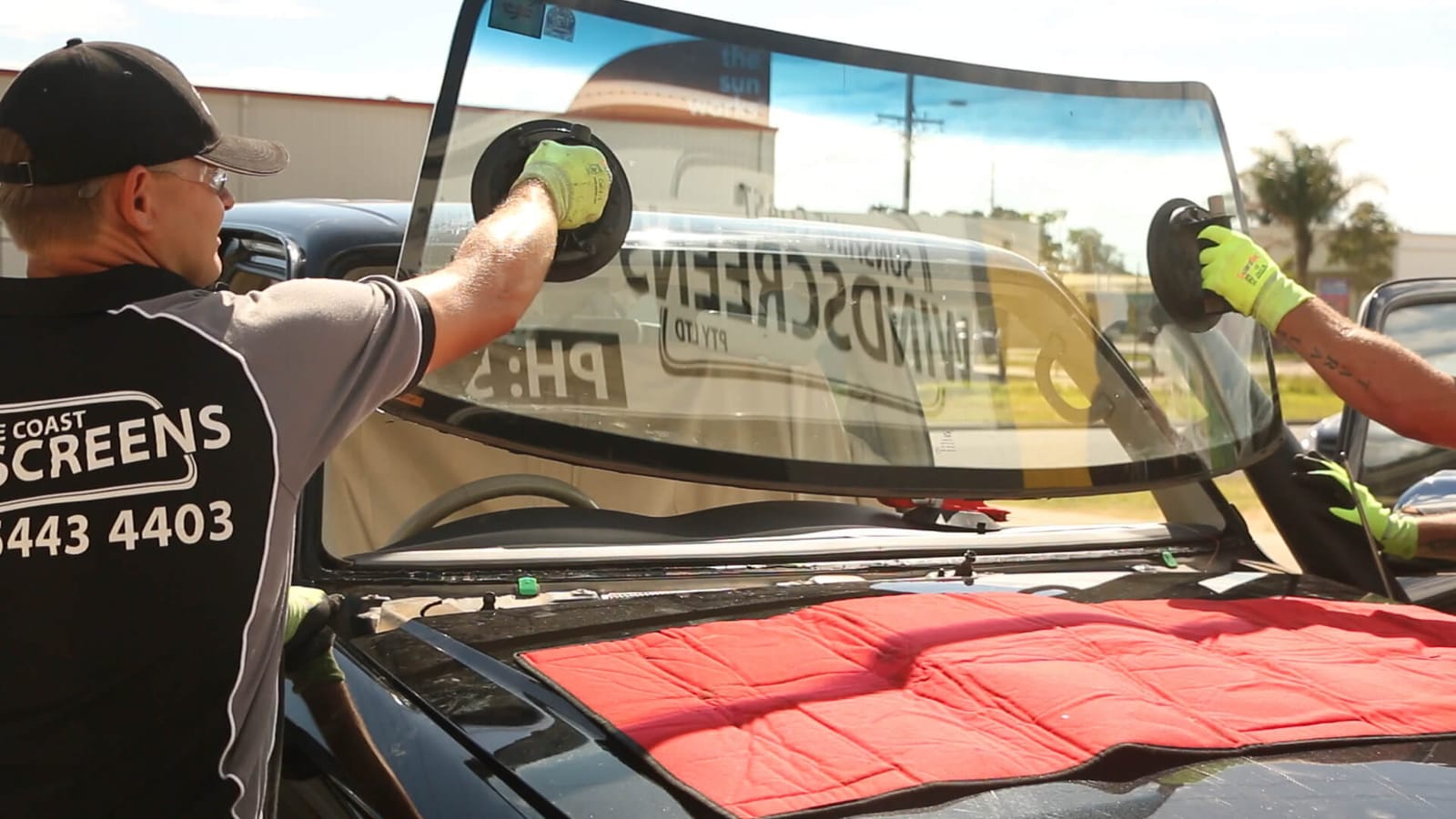 A technician fitting a new windscreen