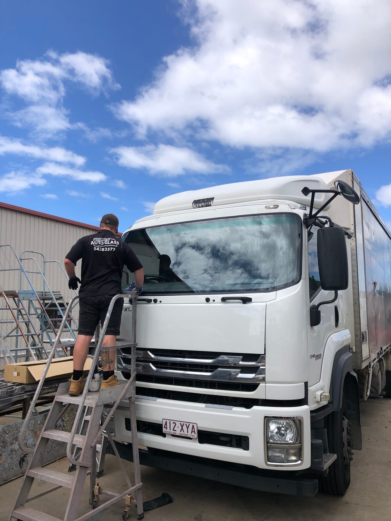 A Morayfield Auto Glass technician in branded uniform beside a truck at the Caboolture South workshop