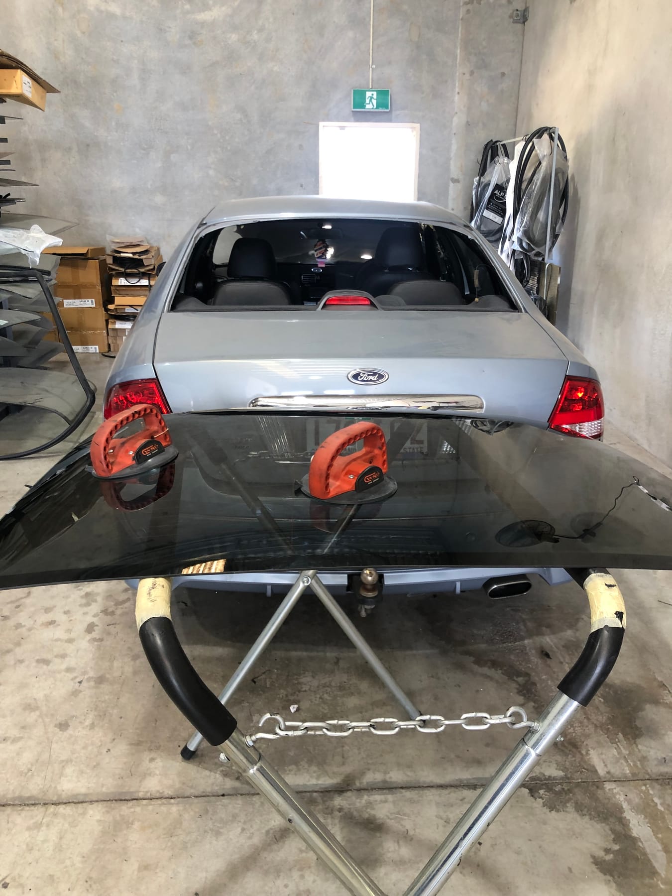 A windscreen lifted out with vacuum suction handles during a replacement at the Morayfield Auto Glass workshop